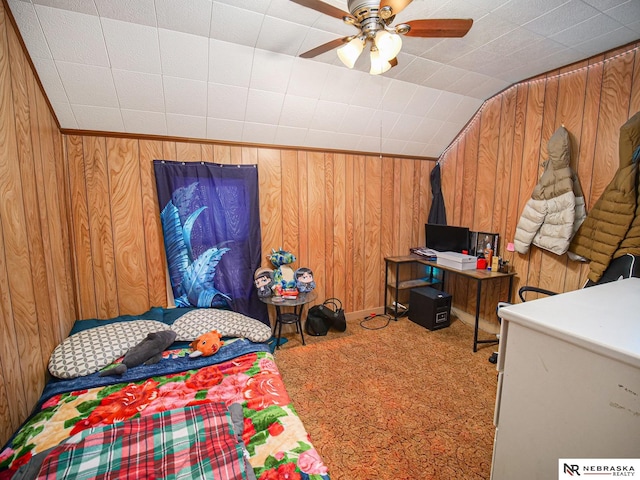 bedroom featuring wood walls, ceiling fan, carpet, white fridge, and vaulted ceiling