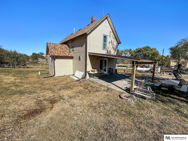 back of property with a patio and a yard