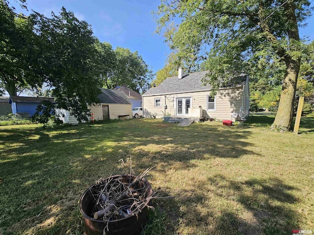 view of yard with an outdoor fire pit and french doors