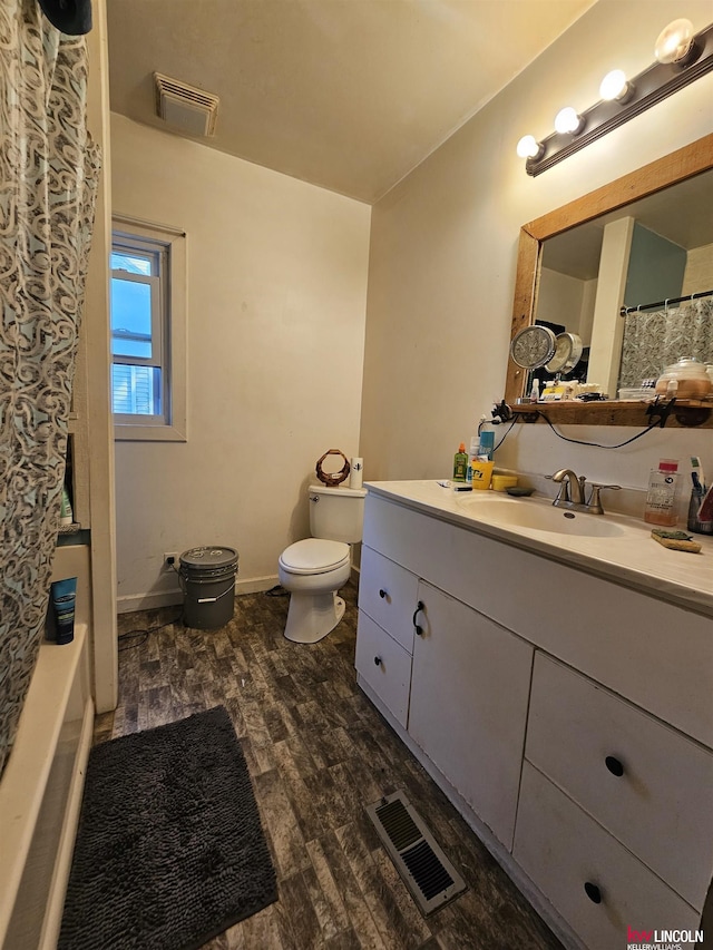 bathroom featuring curtained shower, vanity, wood-type flooring, and toilet