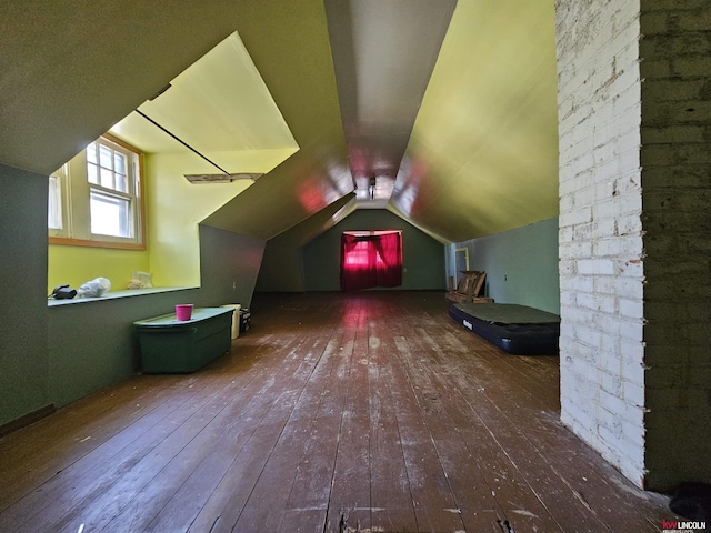 additional living space with dark wood-type flooring and vaulted ceiling