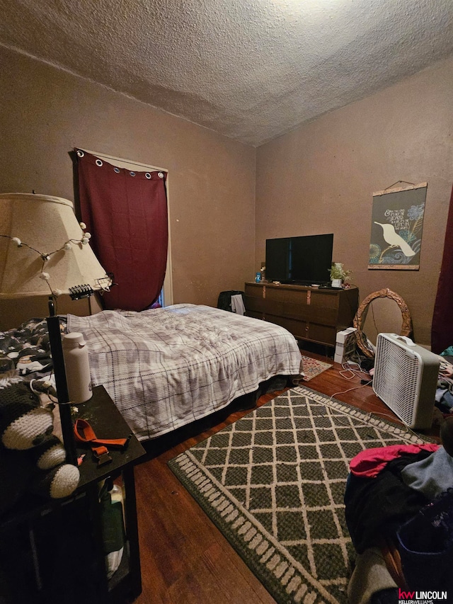 bedroom featuring a textured ceiling and hardwood / wood-style flooring