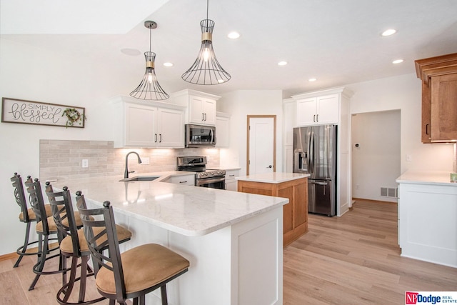 kitchen featuring a kitchen island, appliances with stainless steel finishes, and white cabinetry