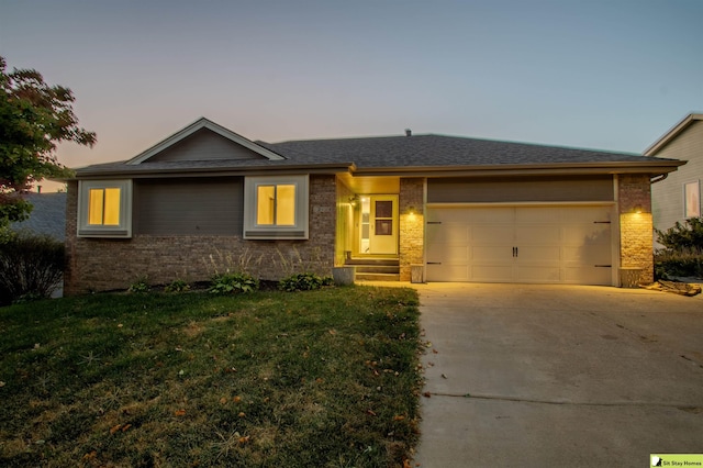 ranch-style home featuring a lawn and a garage