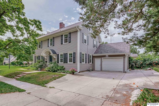 colonial house with a front lawn and a garage