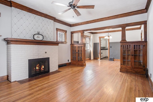 unfurnished living room featuring light wood finished floors, baseboards, a ceiling fan, ornamental molding, and a brick fireplace