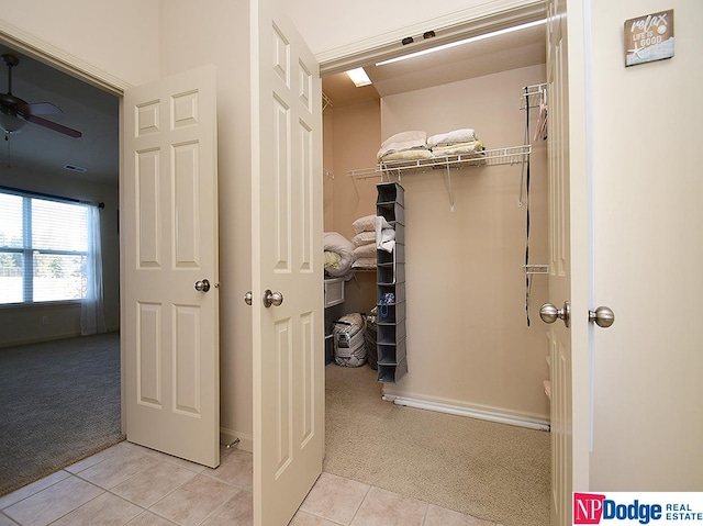 spacious closet with ceiling fan and light colored carpet