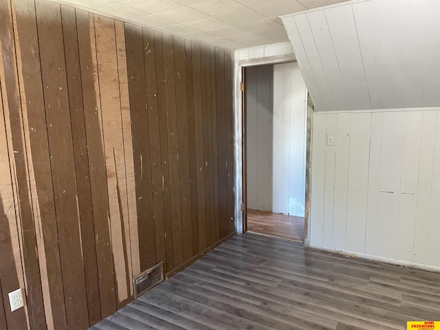 bonus room featuring wooden walls, vaulted ceiling, and dark hardwood / wood-style flooring