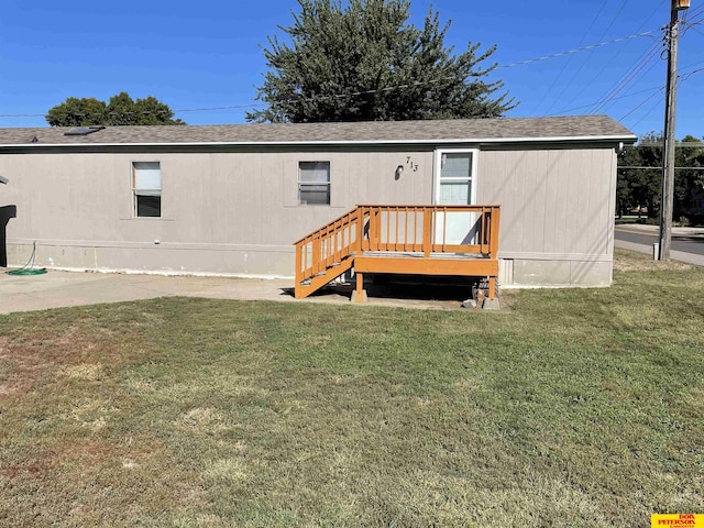 rear view of house with a lawn and a deck