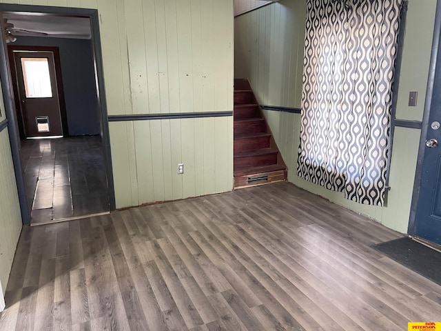 empty room with wood walls and hardwood / wood-style floors