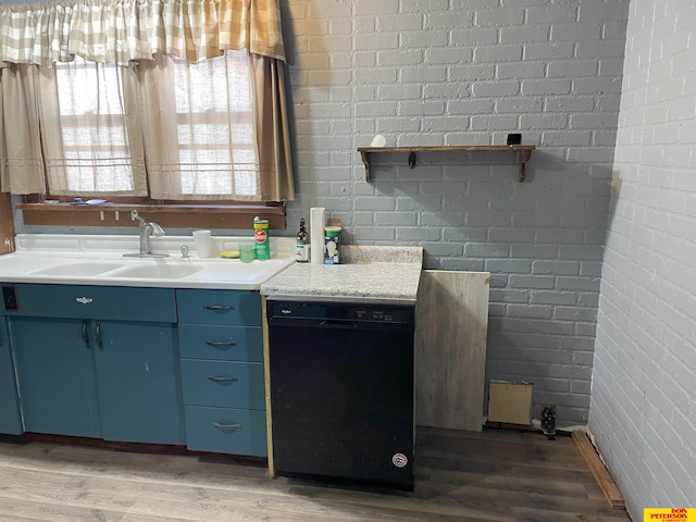 kitchen with wood-type flooring, dishwasher, brick wall, and blue cabinetry