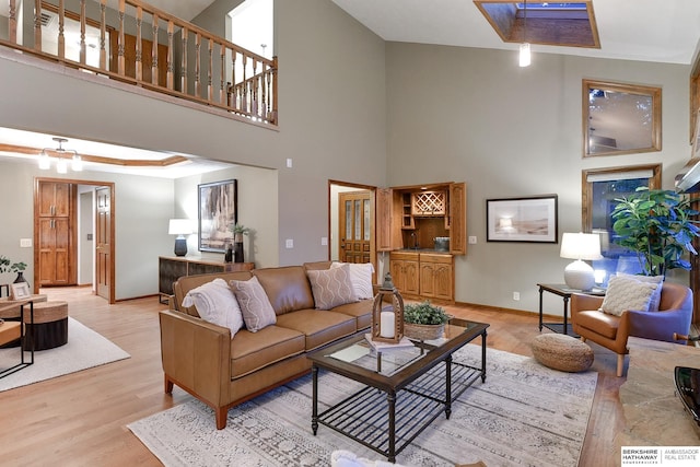 living room featuring a towering ceiling and light hardwood / wood-style floors