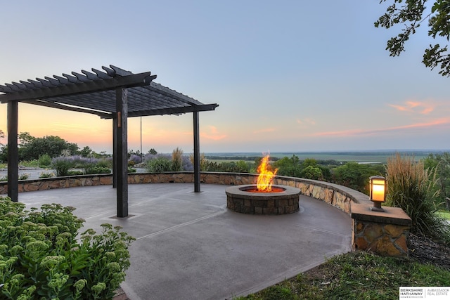 patio terrace at dusk with an outdoor fire pit and a pergola