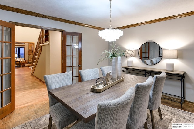 dining area with an inviting chandelier, ornamental molding, french doors, and light parquet flooring