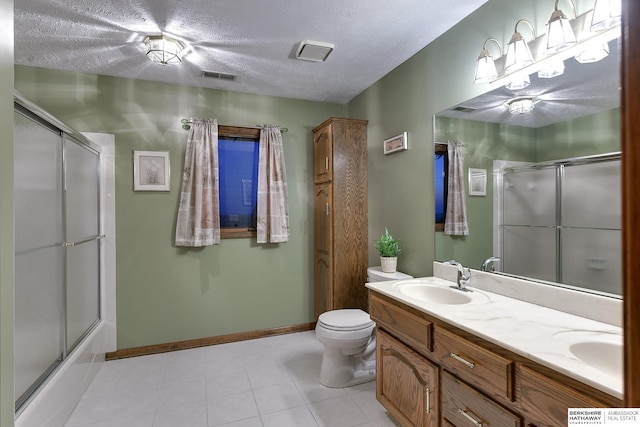 full bathroom featuring vanity, bath / shower combo with glass door, a textured ceiling, and toilet