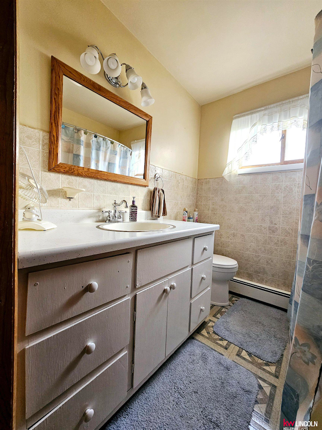 bathroom with toilet, a baseboard heating unit, vanity, and tile walls