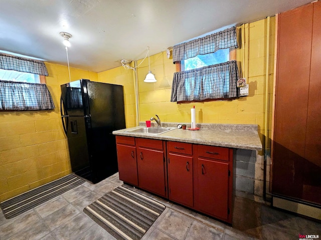 kitchen featuring black fridge, a baseboard radiator, decorative light fixtures, and sink