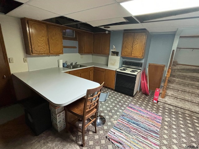 kitchen featuring a paneled ceiling, kitchen peninsula, electric stove, and sink