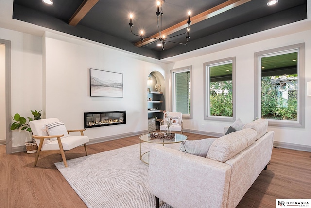 living room featuring hardwood / wood-style floors, a chandelier, and a raised ceiling