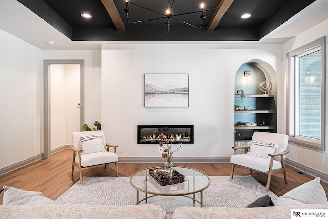 living area featuring wood-type flooring and beamed ceiling