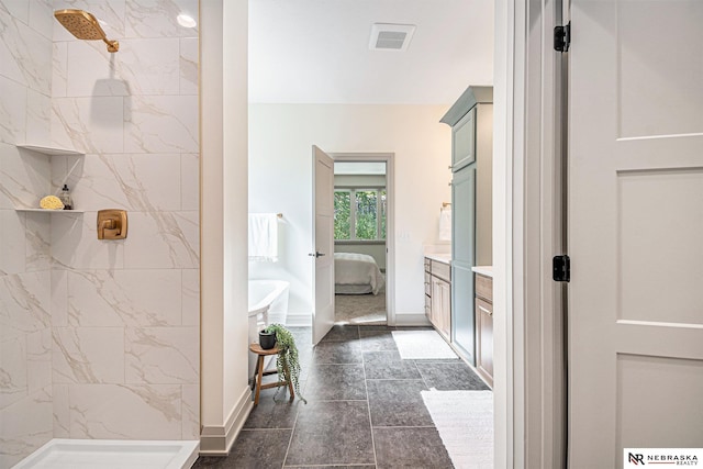 bathroom with tile patterned floors, vanity, and tiled shower