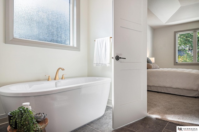 bathroom with a bathtub and tile patterned floors