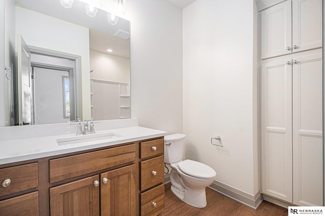 bathroom featuring wood-type flooring, vanity, and toilet