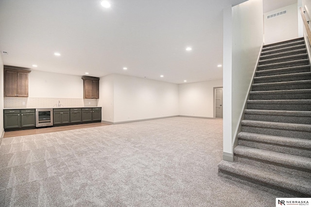 basement featuring light colored carpet and beverage cooler