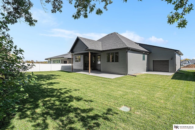 rear view of property featuring a lawn and a garage