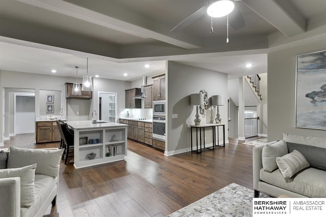 living room with dark hardwood / wood-style flooring, ceiling fan, and sink