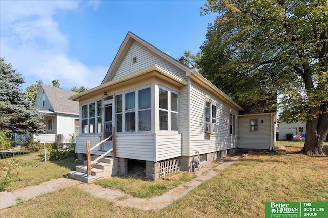 exterior space with a yard, a sunroom, and cooling unit