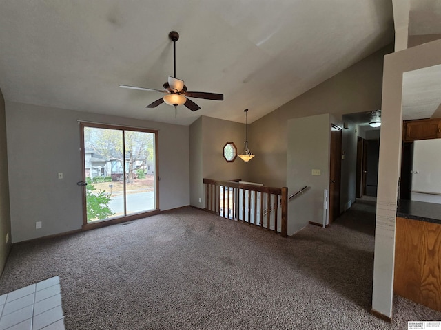 carpeted spare room with vaulted ceiling and ceiling fan