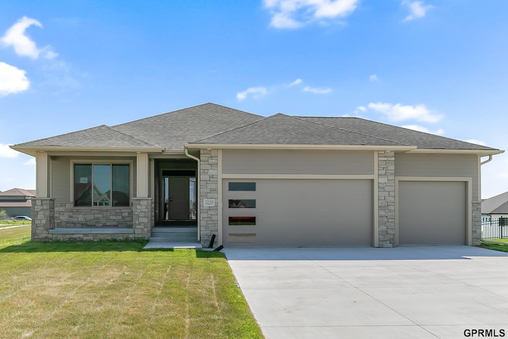 prairie-style house featuring a front lawn and a garage