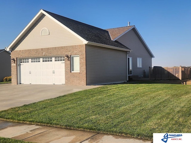 view of side of property featuring a garage and a lawn