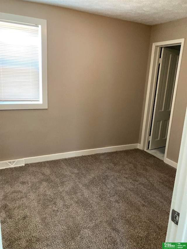 empty room featuring a textured ceiling and carpet floors