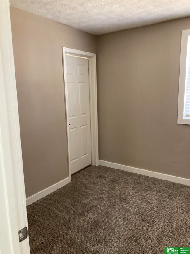 carpeted spare room with a textured ceiling