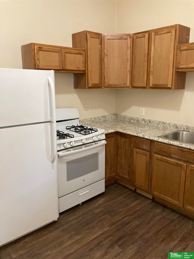 kitchen with white appliances, sink, and dark hardwood / wood-style floors