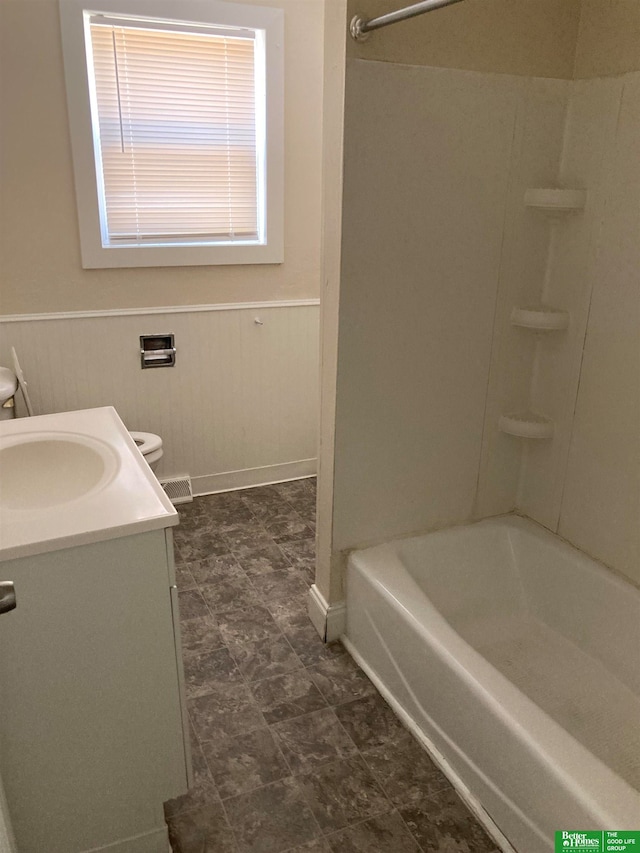 full bathroom featuring vanity, wooden walls, shower / washtub combination, and toilet