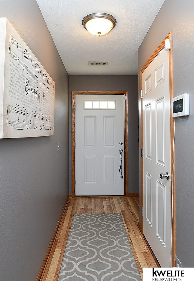 entryway featuring light hardwood / wood-style flooring and a textured ceiling