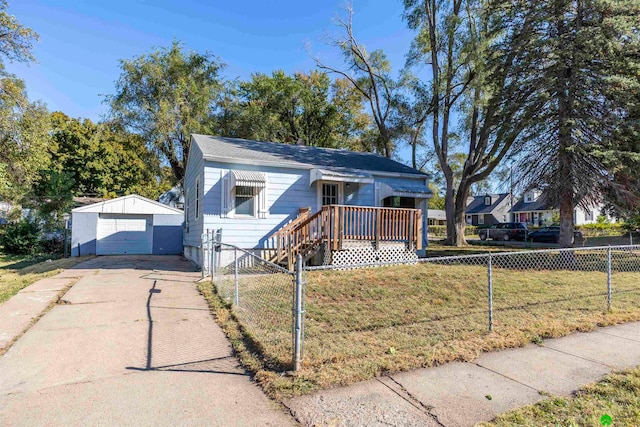 bungalow featuring a garage, a front lawn, and an outbuilding