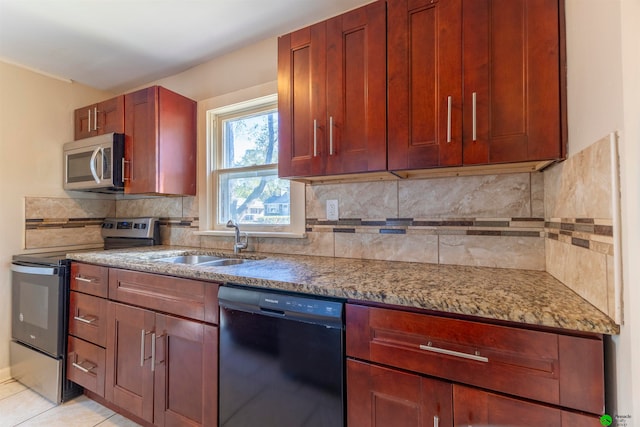 kitchen with sink, light stone countertops, stainless steel appliances, and tasteful backsplash