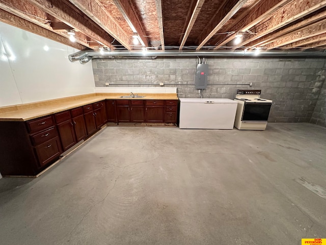 basement featuring refrigerator, electric panel, and sink