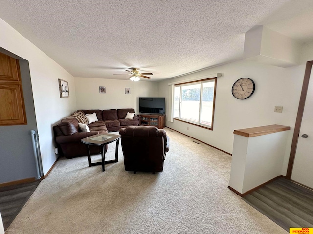 carpeted living room with a textured ceiling and ceiling fan