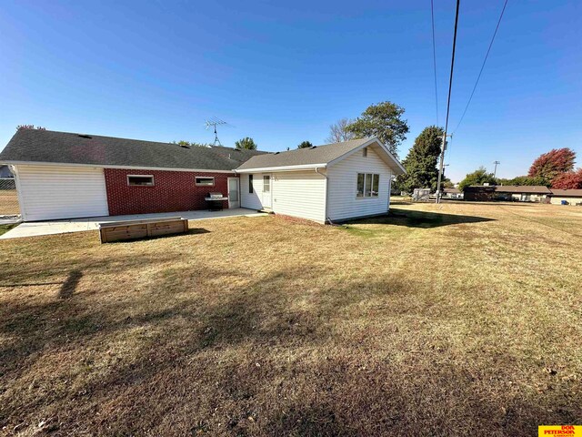 rear view of property featuring a yard and a patio area