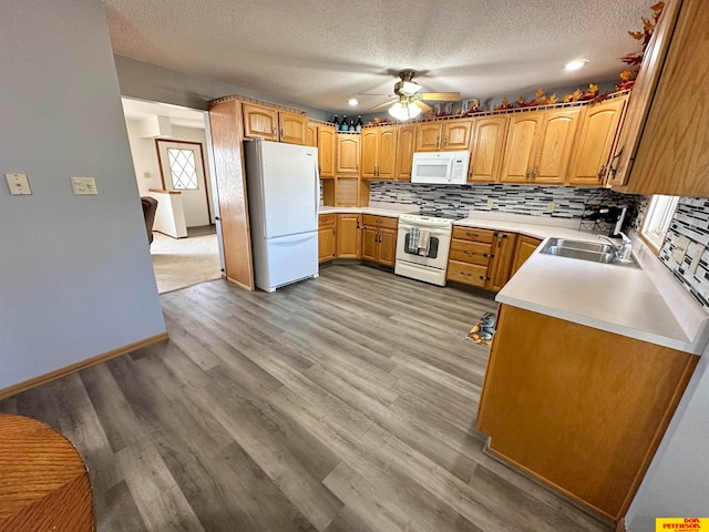 kitchen featuring ceiling fan, a textured ceiling, light wood-type flooring, sink, and white appliances