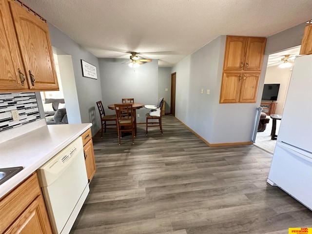 kitchen with a textured ceiling, dark wood-type flooring, backsplash, and white appliances