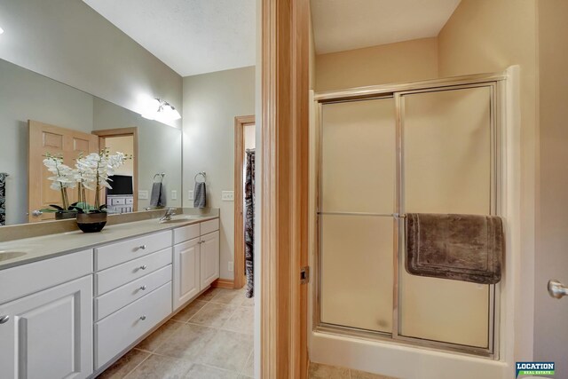 bathroom featuring vanity, tile patterned floors, and walk in shower