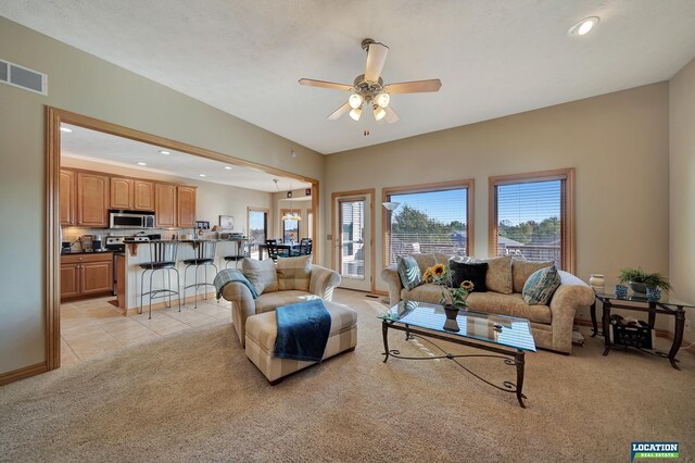 carpeted living room with ceiling fan