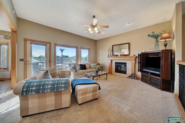 carpeted living room with a fireplace and ceiling fan