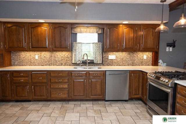 kitchen featuring backsplash, appliances with stainless steel finishes, sink, and decorative light fixtures